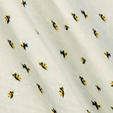 Milkbarn Bamboo Bumblebee Swaddle Blanket, close-up of the yellow and black bee print on sage muslin
