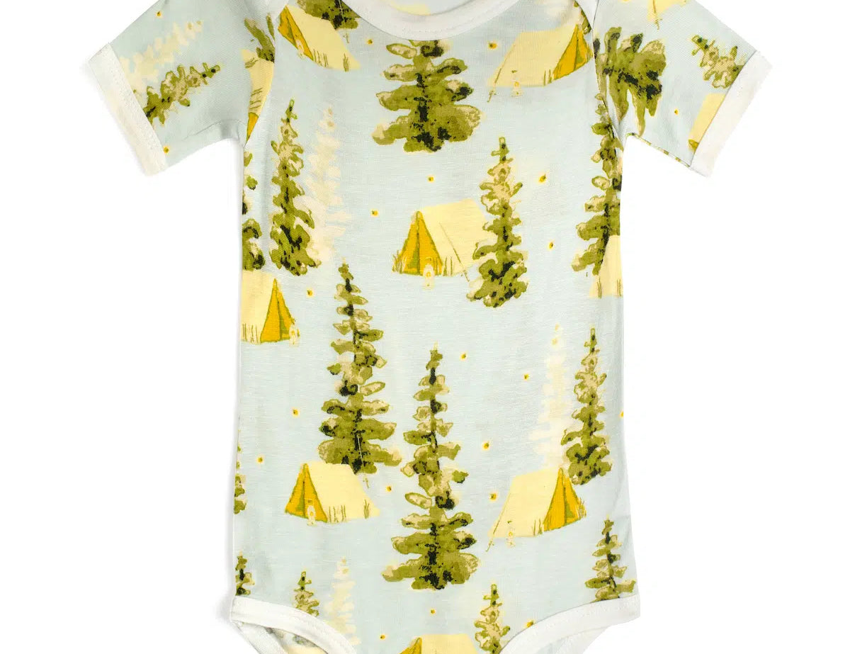Milkbarn Camping Short Sleeve One Piece, a light blue baby bodysuit with a pine tree and yellow tent print