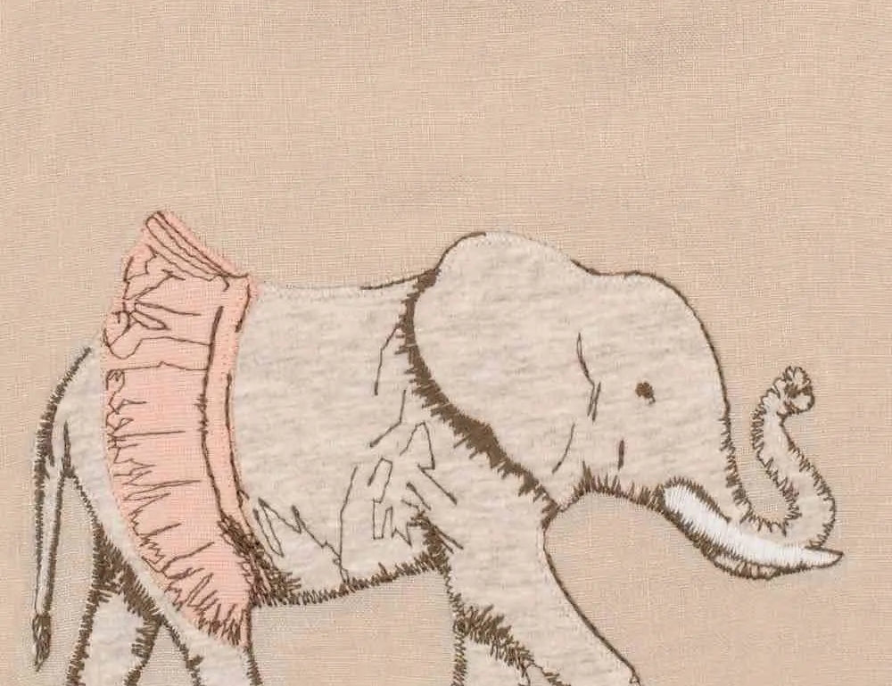 Close-up of the embroidered elephant in a pink tutu on the Milkbarn Tutu Elephant Linen Bib