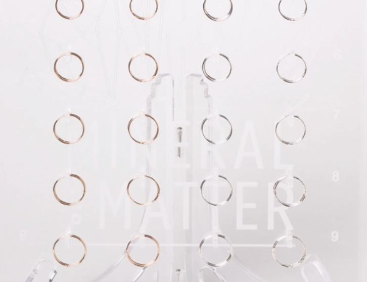 Mineral and Matter Stacking Rings, thin gold rings displayed on a clear acrylic stand