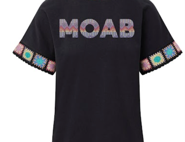 Black Moab tee with woven pastel lettering and crocheted granny square trim at the cuffs