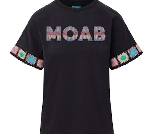 Black Moab tee with woven pastel lettering and crocheted granny square trim at the cuffs