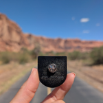 Back of the Moab Utah sunburst enamel pin showing the rubber clutch.