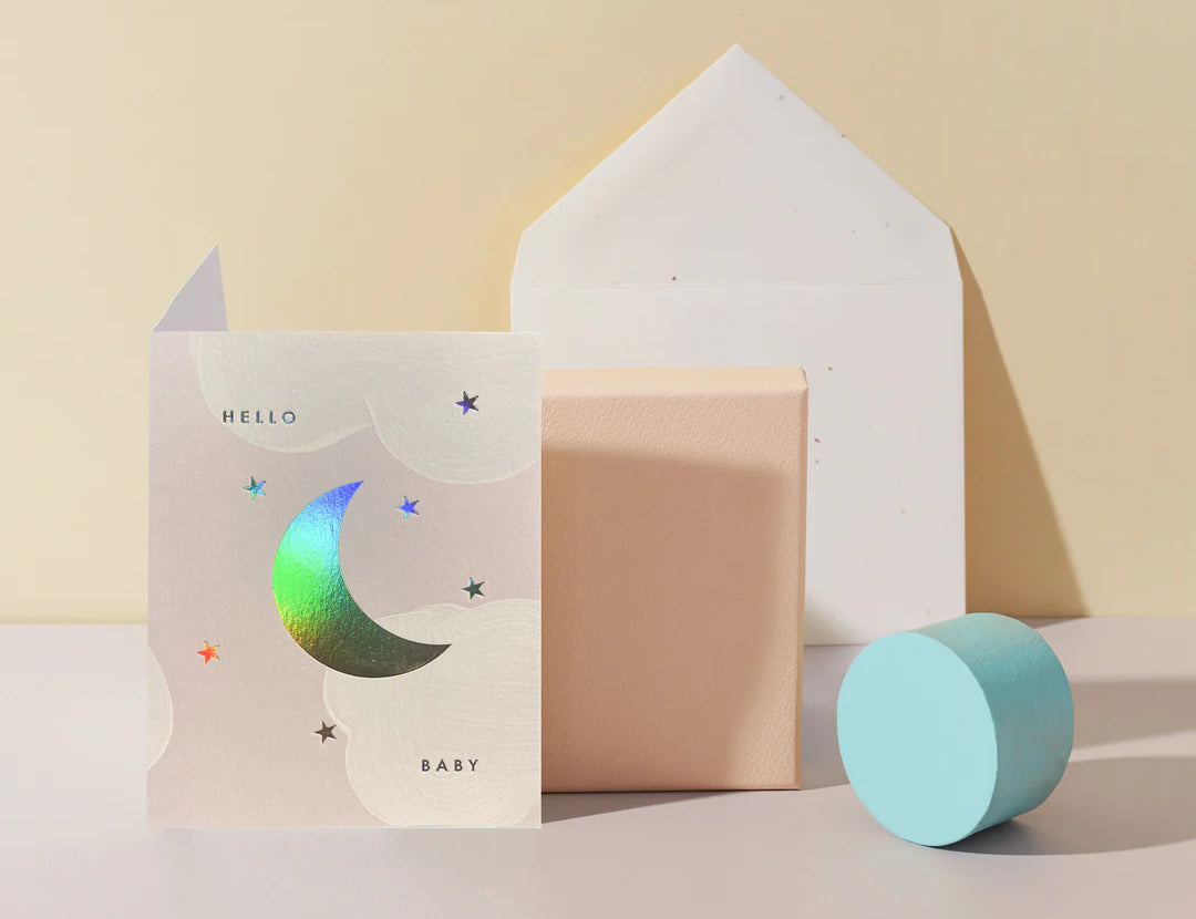 Moglea Moon Baby Card styled with pastel paper shapes and a white envelope