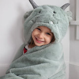 Smiling child wrapped in the Mon Ami Dax Dragon Plush Blanket with the dragon hood up