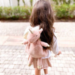 Girl with long dark hair wearing the Mon Ami Luna Unicorn Backpack, back view