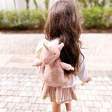 Girl with long dark hair wearing the Mon Ami Luna Unicorn Backpack, back view