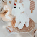Mon Ami Wes The Westie plush sitting on a pink cake stand at a party