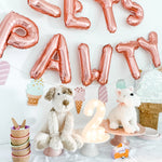 Mon Ami Wes The Westie plush at a puppy party with rose gold Let's Pawty balloons
