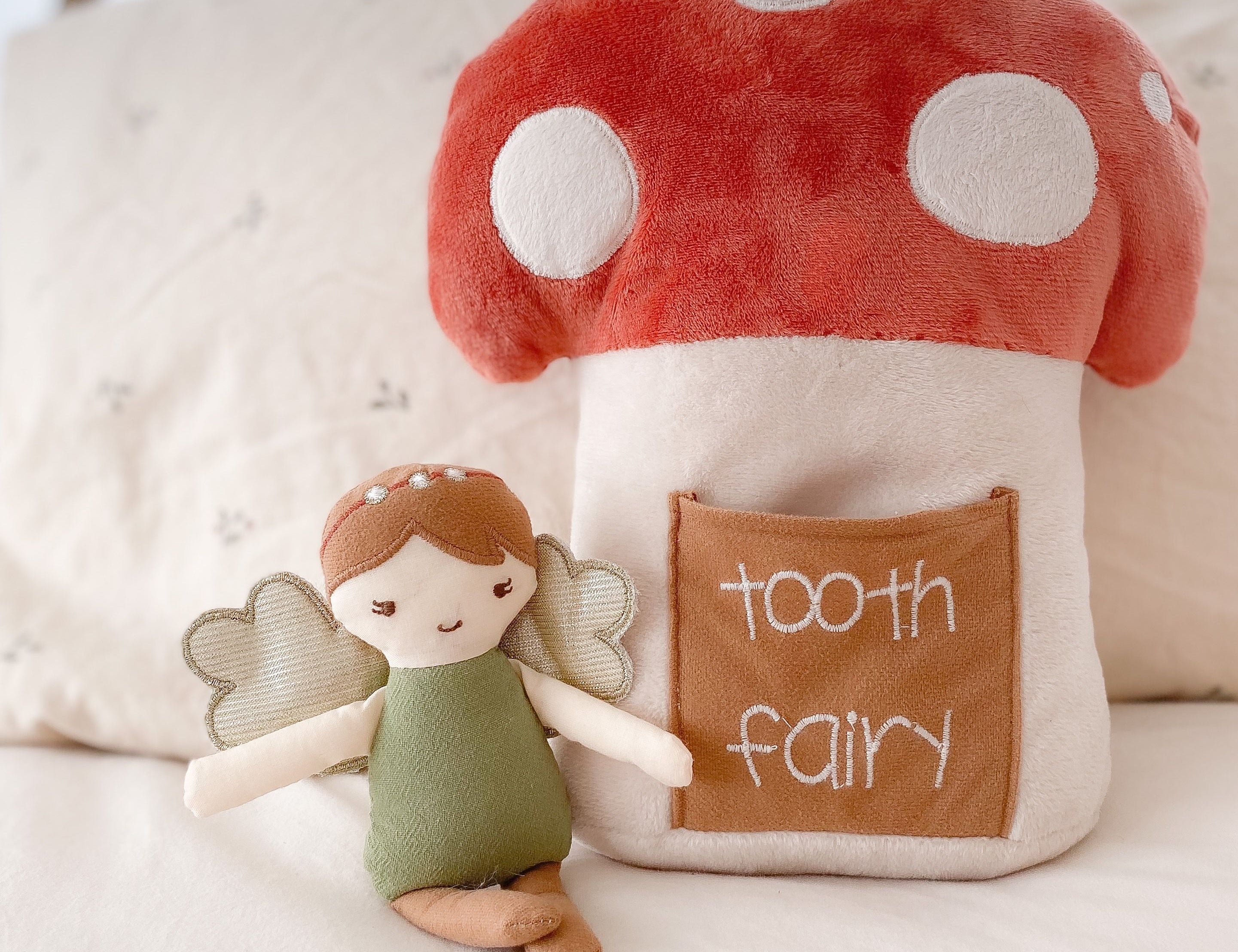 Mon Ami Woodland Fairy Tooth Fairy Pillow Set on a bed with the fairy doll beside the mushroom pillow