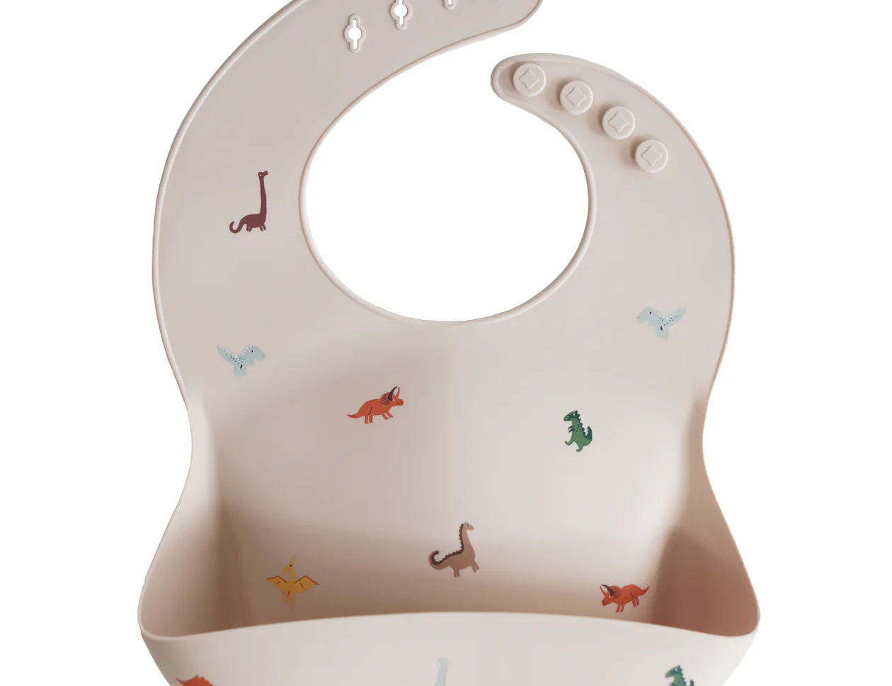 Mushie Silicone Baby Bib in Dinosaurs, a blush bib with a colorful dinosaur print and a catch pocket