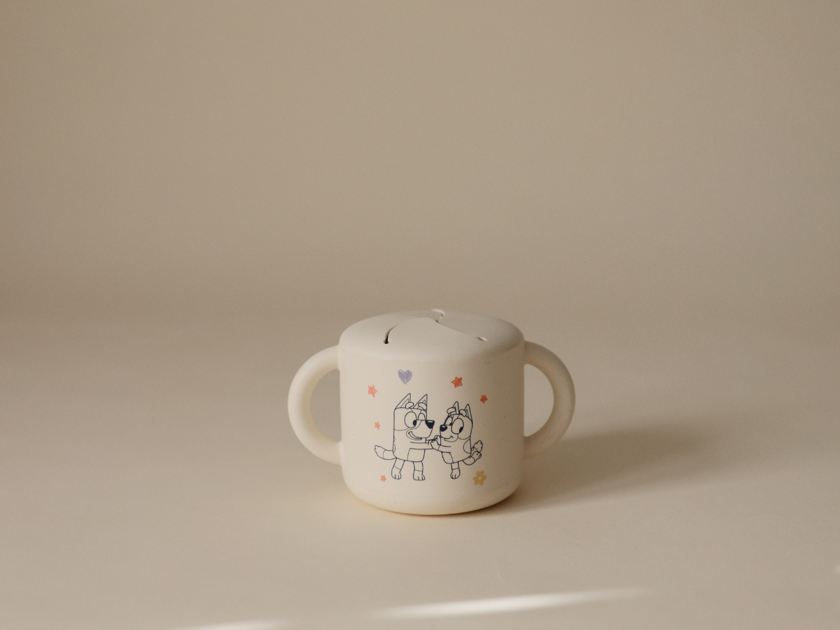 Mushie Snack Cup in Bluey Ivory on a neutral surface in soft light