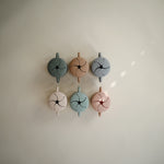 Six Mushie Snack Cups in assorted colors arranged on a wall showing the slotted lids