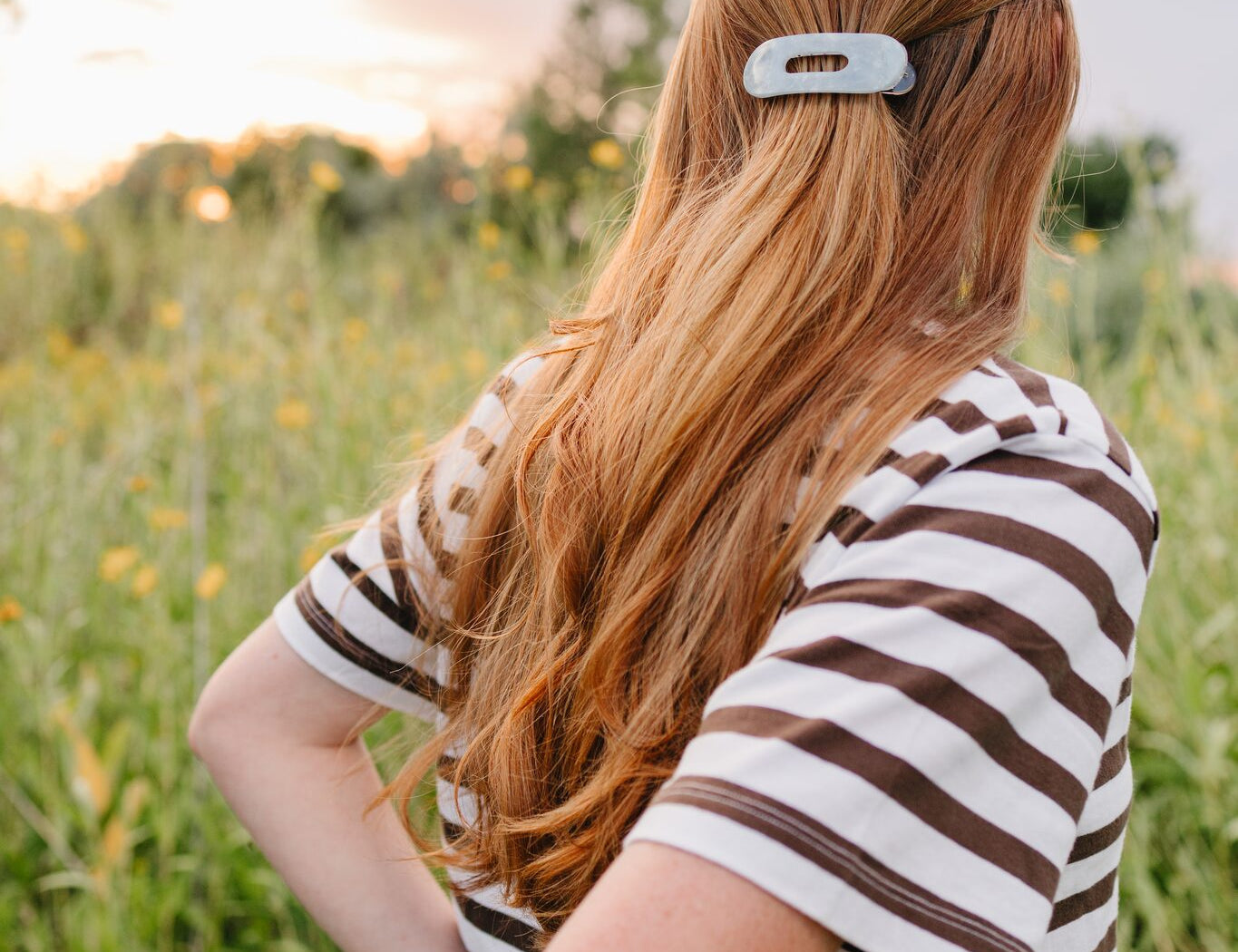 The Moonstone oval lay flat acrylic claw clip sitting flat against the back of the head in a half up style.