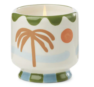 Cream ceramic candle hand painted with a terracotta palm tree, orange sun and green scalloped rim