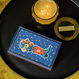 Cobalt blue Paddywax matchbox with a cowboy boot holding flowers and gold stars, second view