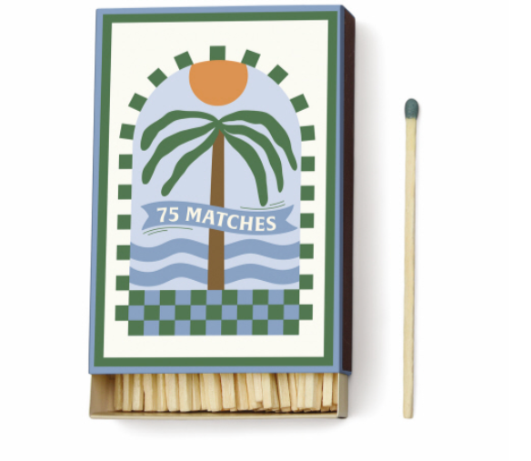 Paddywax Dopo matchbox with a green palm tree, orange sun and blue waves in a checkered border