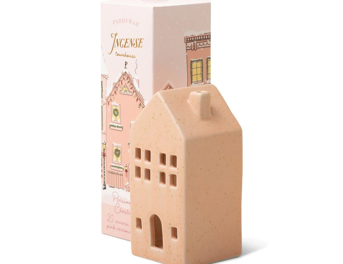 Paddywax Persimmon Chestnut Ceramic Incense Townhouse, a speckled pink ceramic house-shaped incense cone holder beside its illustrated holiday box
