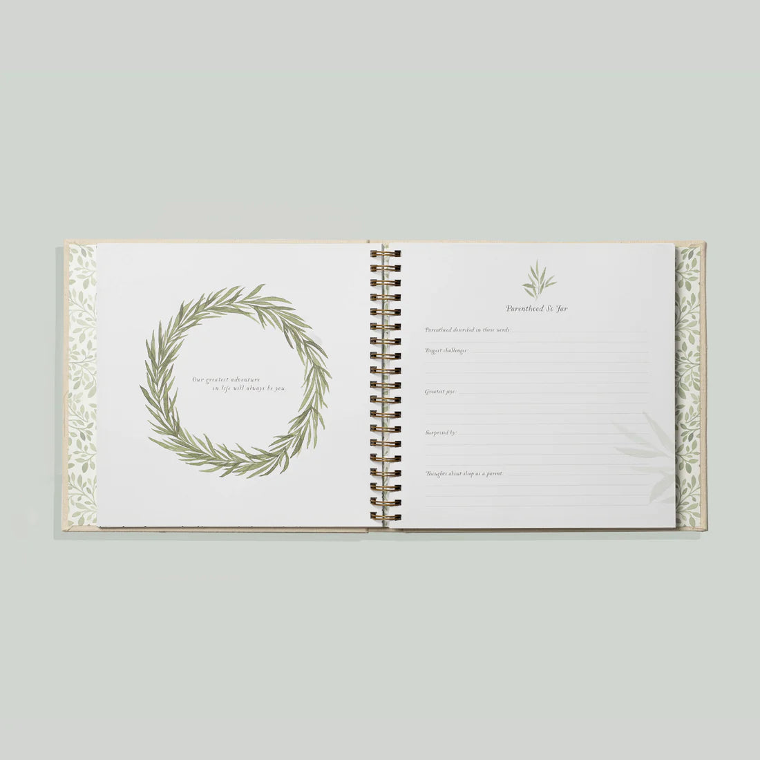 Paige Tate & Co As You Grow Memory Book, open spread with a leafy wreath and a fill-in milestone page