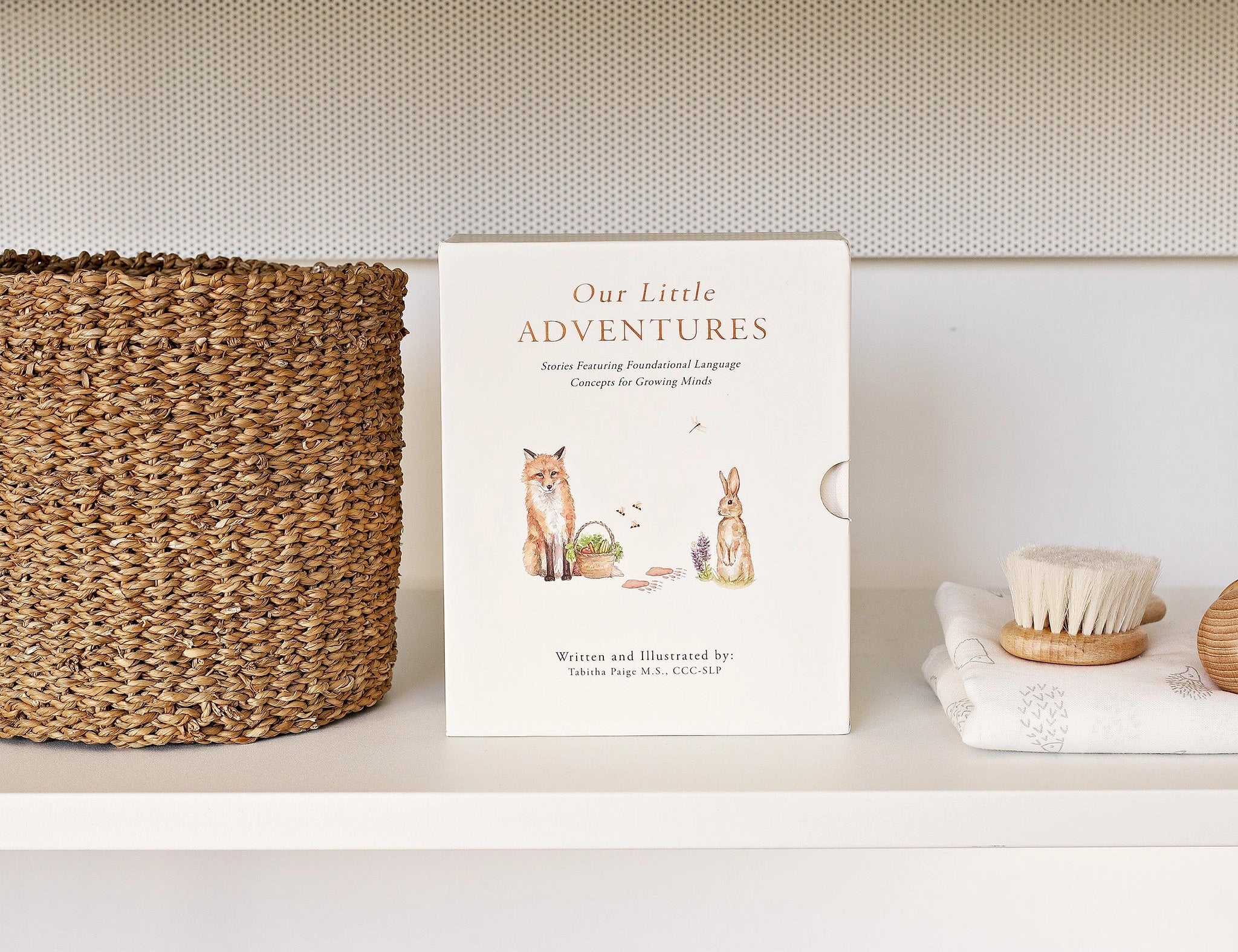 Paige Tate & Co Our Little Adventures Box Set on a white shelf beside a woven basket