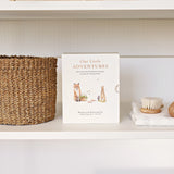 Paige Tate & Co Our Little Adventures Box Set on a white shelf beside a woven basket