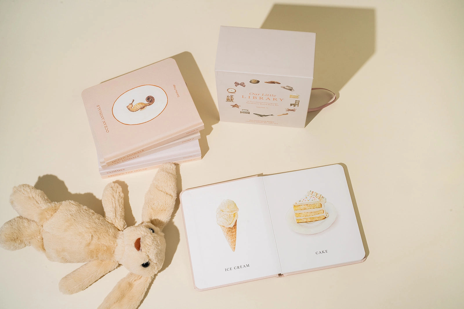 Paige Tate & Co Our Little Library Vol. 2 board books open beside a plush bunny