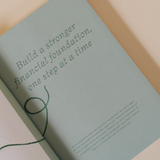 Papier Finance Planner Four Leaf sage green inside page reading Build a stronger financial foundation, one step at a time