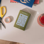 Papier Good Day Stamp Planner Set box on a desk with scissors and washi tape
