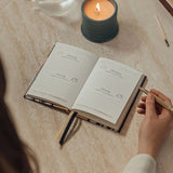 Papier Guided Gratitude Journal A6 Stripe Bouquet open on a table beside a lit candle