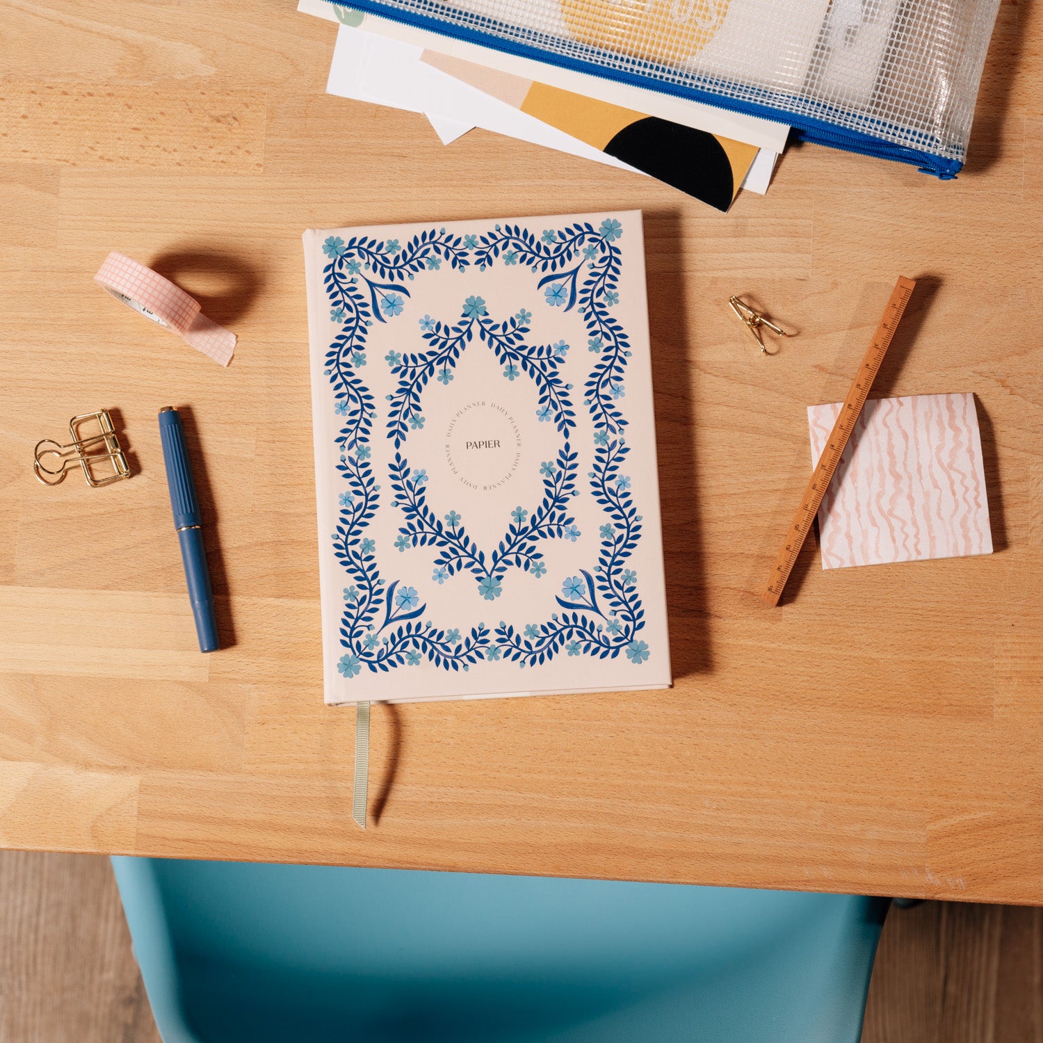 Papier Italian Summer Daily Productivity Planner closed on a wooden desk with a pen and pouch