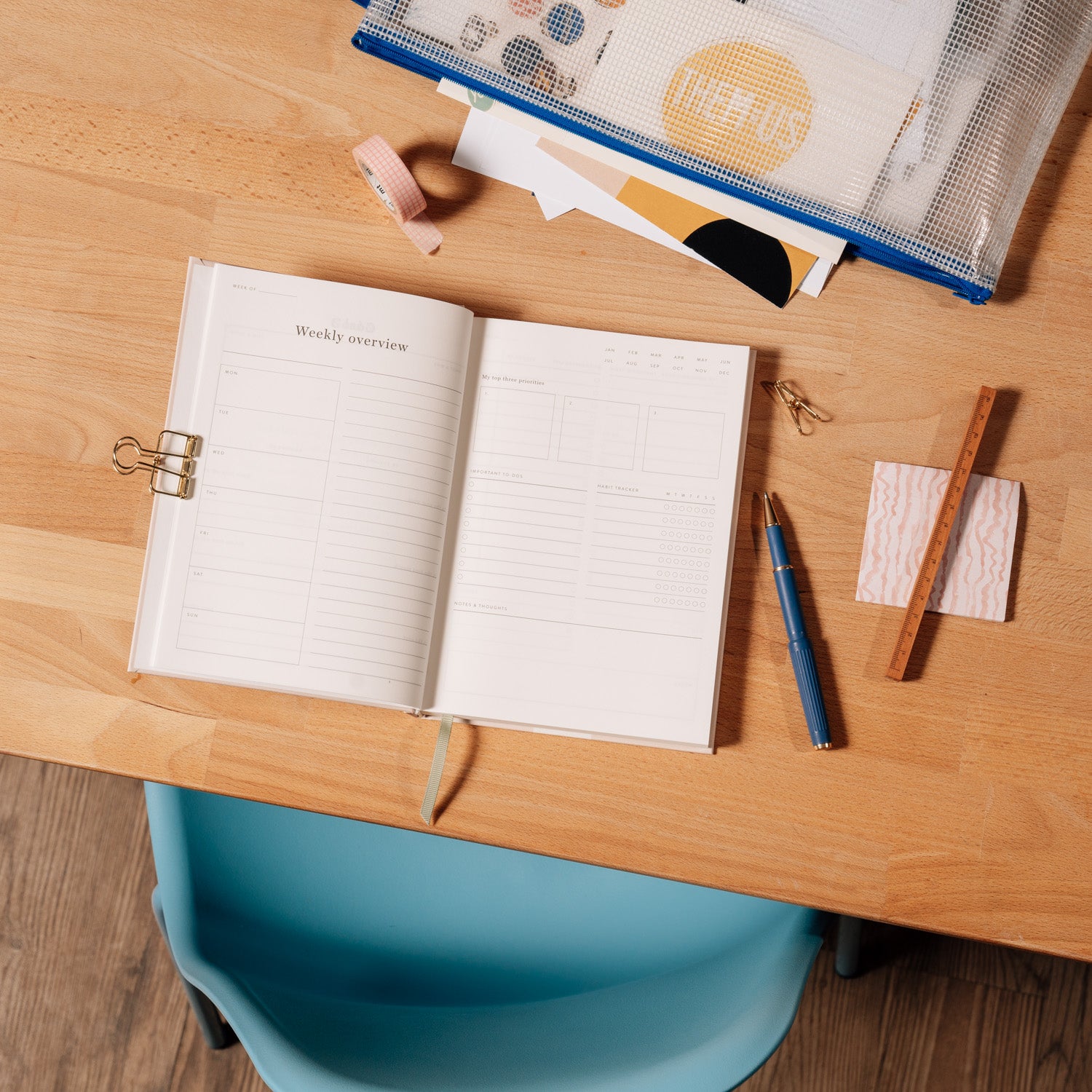 Papier Italian Summer Daily Productivity Planner open on a wooden desk with a pen and clips