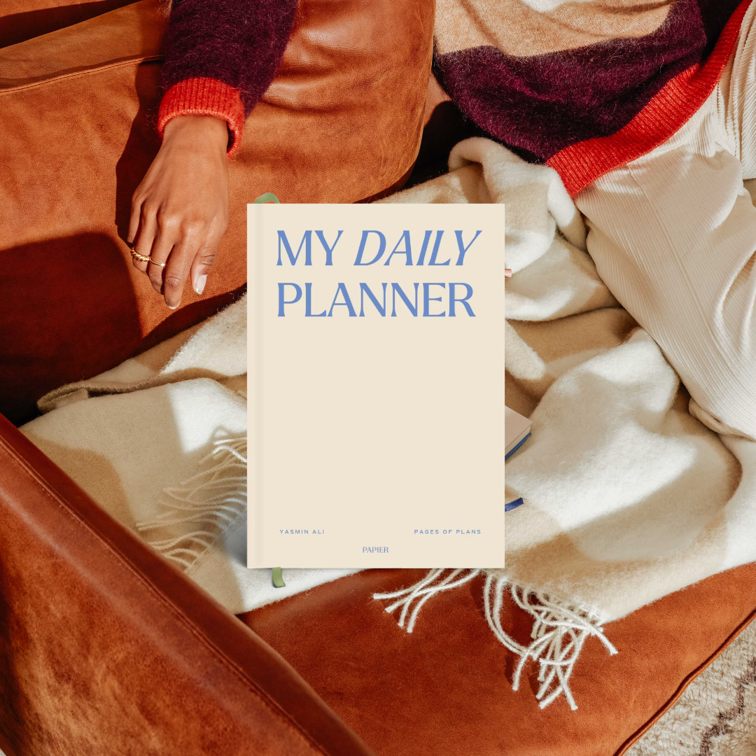 Papier My Daily Planner Wonder resting on a blanket on a leather chair