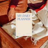 Papier My Daily Planner Wonder resting on a blanket on a leather chair
