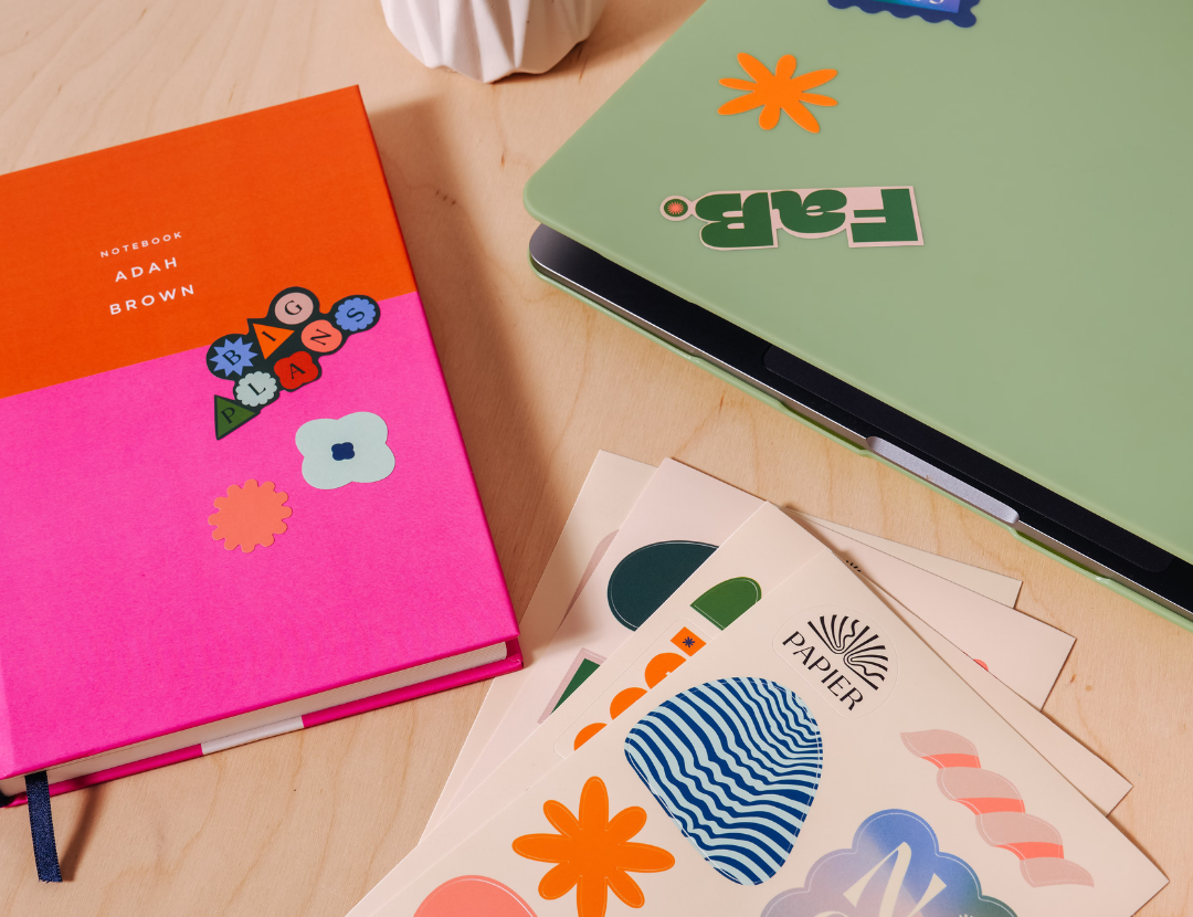 Papier Nice and Fabs Stickers applied to a pink notebook and a green laptop