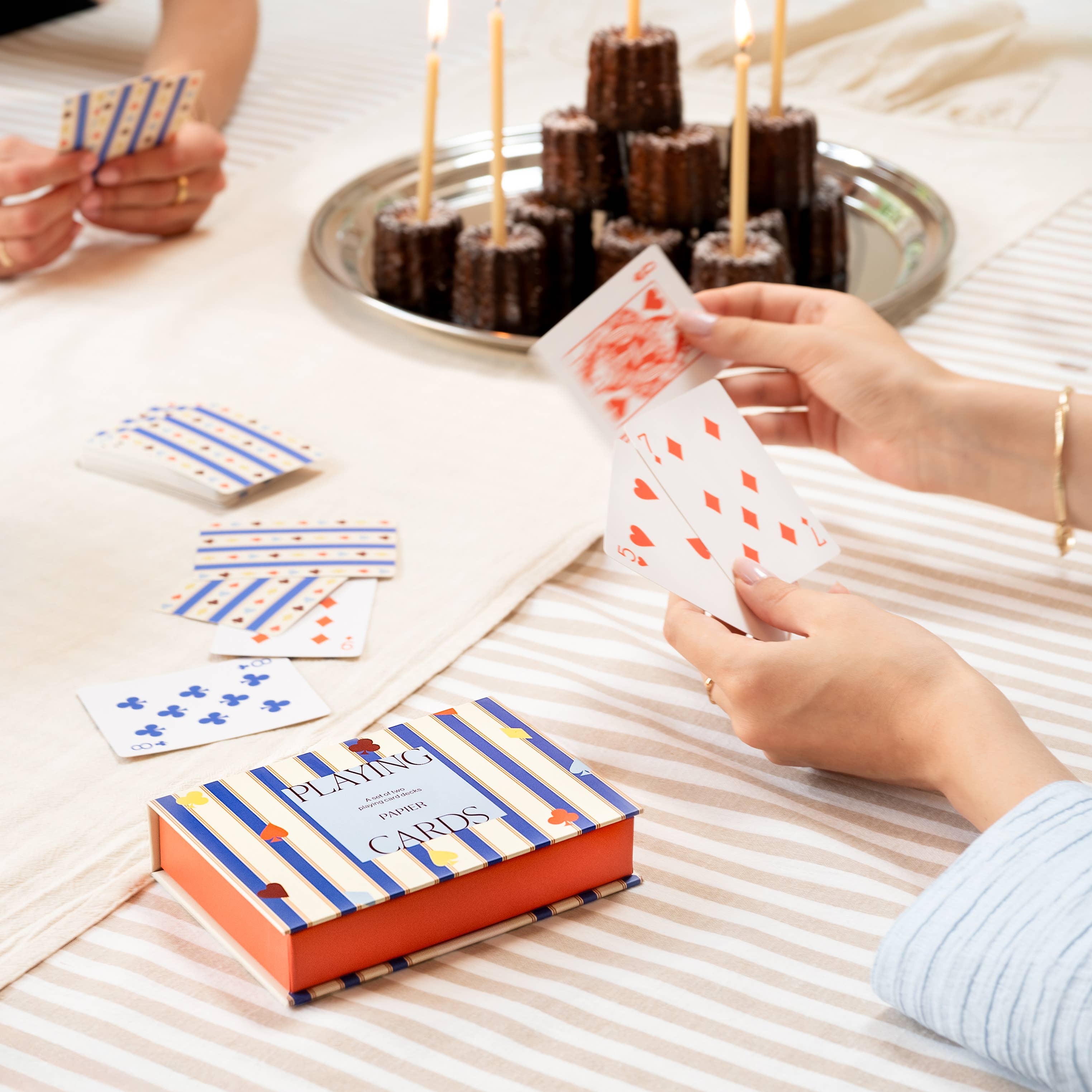 Papier Playing Cards Suits & Stripes on a picnic blanket with a tray of chocolate cakes
