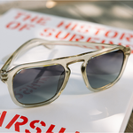 Peepers Deep Dive Sunglasses in Fog resting on a book