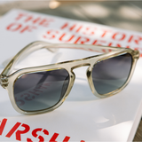 Peepers Deep Dive Sunglasses in Fog resting on a book