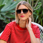 Woman in a red striped shirt wearing Peepers Deep Dive Sunglasses in Mocha Tortoise