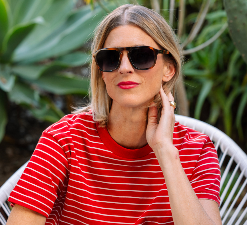 Woman in a red striped shirt wearing Peepers Deep Dive Sunglasses in Mocha Tortoise