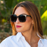 Woman in a white shirt wearing Peepers Frenchy Sunglasses in Green/Leopard Tortoise outdoors