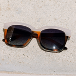 Peepers Frenchy Sunglasses in Mocha Tortoise/Cream resting on a stone surface