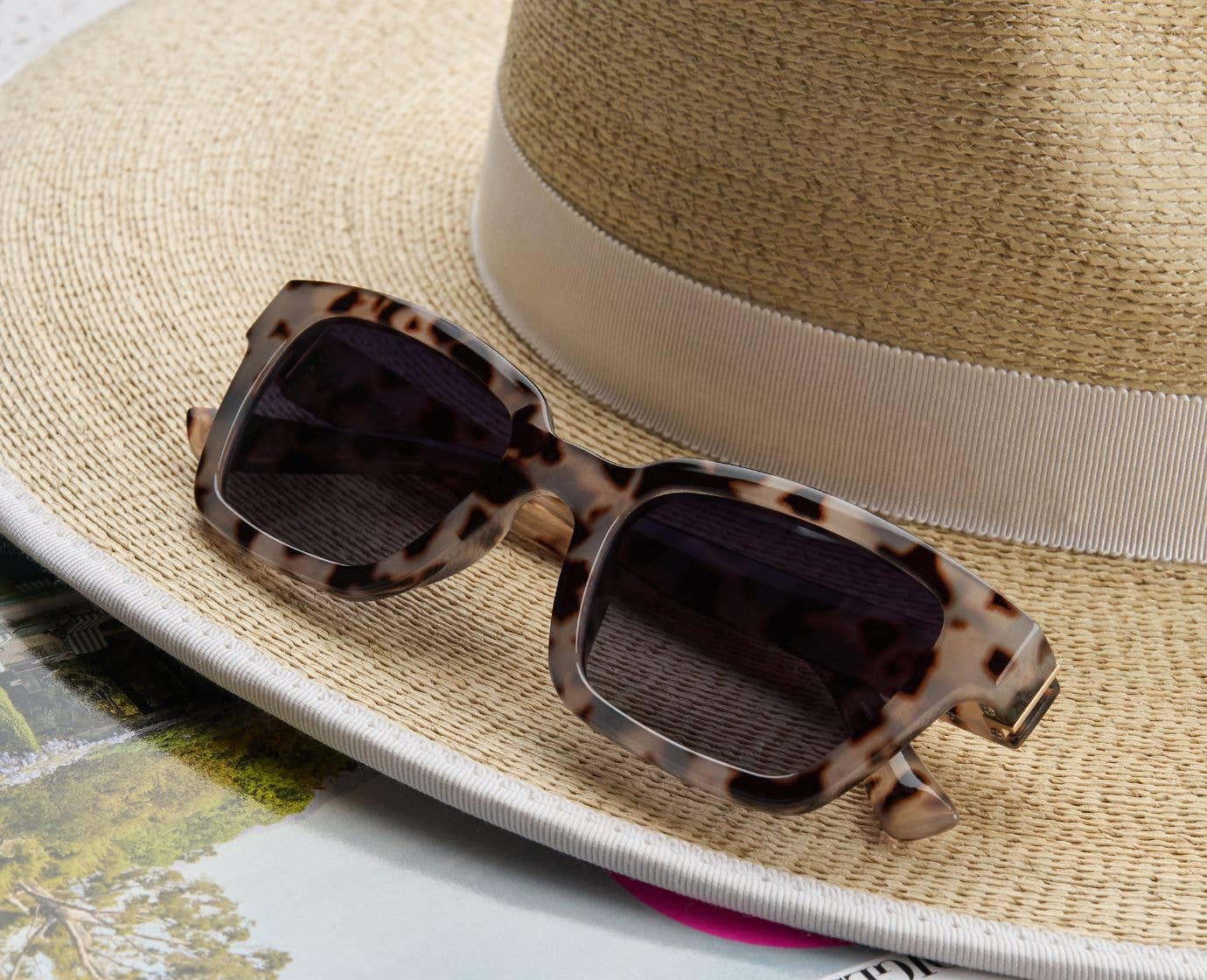 Peepers Myrtle Sunglasses in Gray Tortoise resting on a straw hat