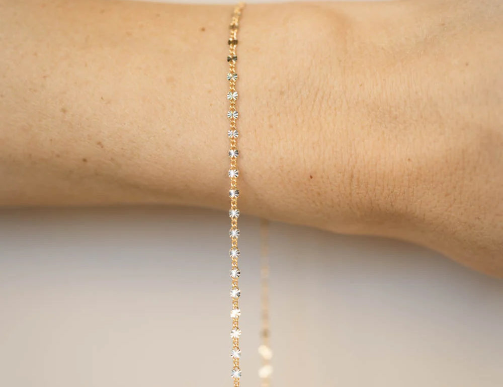A gold filled permanent bracelet welded closed on a wrist, no clasp, fitted in store at Desert Sol in Moab.