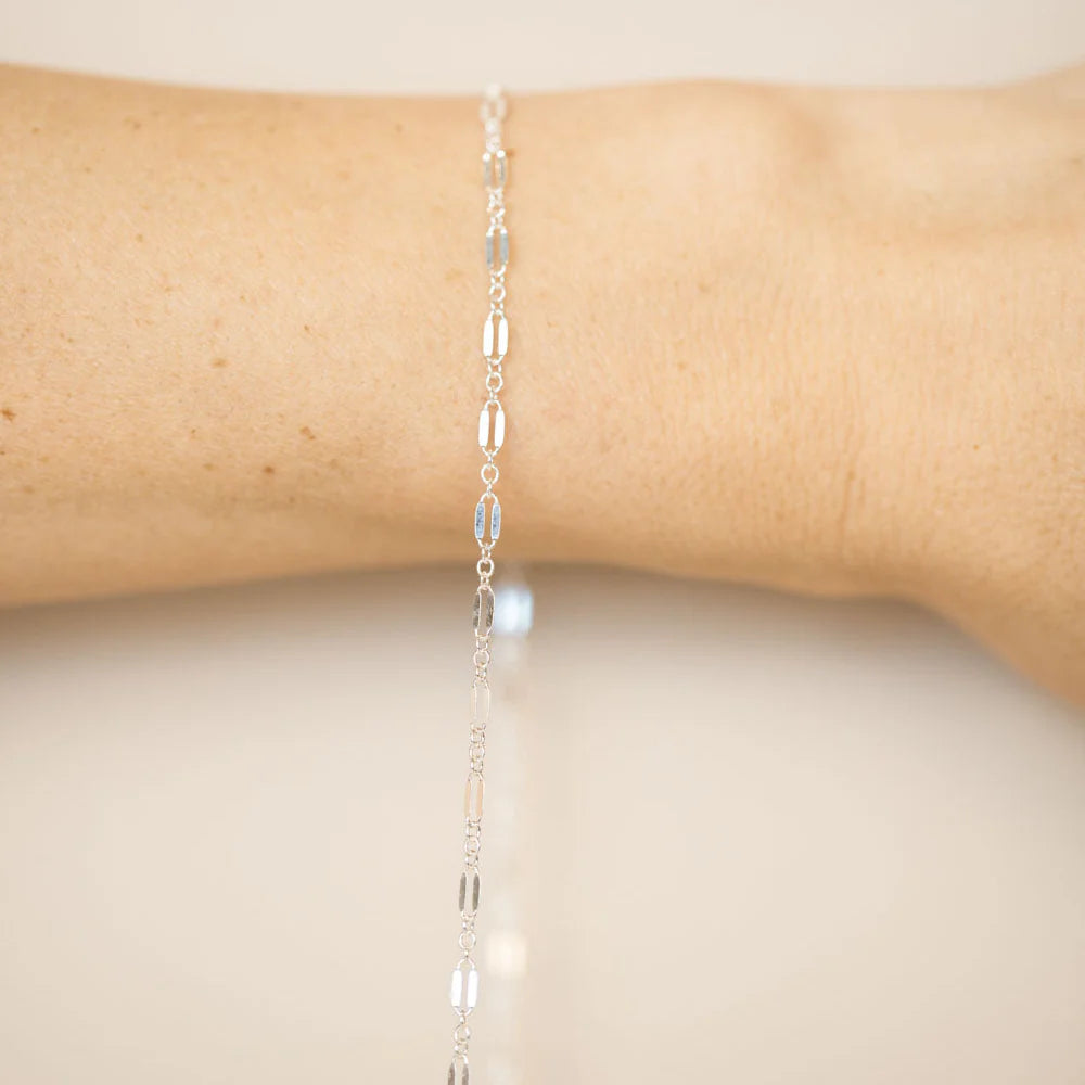 A sterling silver permanent bracelet welded closed on a wrist, no clasp, fitted in store at Desert Sol in Moab.