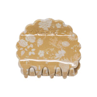 Petal claw clip in Canyon Rose, a glossy scalloped hair claw clip printed with white roses and daisies on a warm clay rose ground, on a white background.