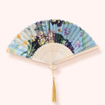 Powder Designs Satin Fan in Spring Flora, a blue and floral folding fan with a gold tassel