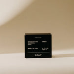 Preston Bar Soap in Amber, black boxed detoxifying charcoal soap on a tan background