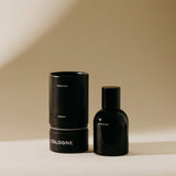 Preston Cologne in Amber, a matte black bottle beside its black cylinder box
