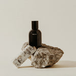 Preston Cologne matte black bottle resting on a rough stone