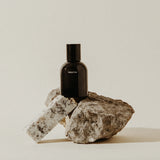Preston Cologne matte black bottle resting on a rough stone